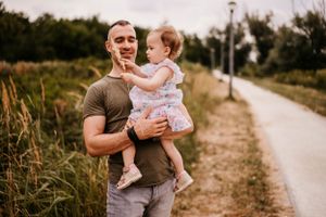 Outdoor portrait on a rural path surrounded by tall grass.