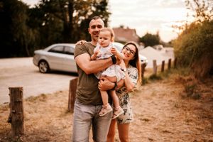 Happy family sharing joyful moments together on a dirt path at sunset.