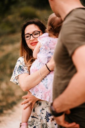 An intimate family moment captured in warm sunlight among natural surroundings.