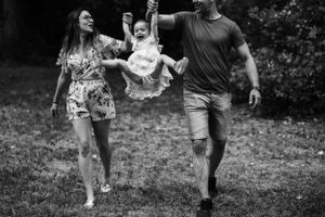 A black and white photo of a family playing together in a garden setting.