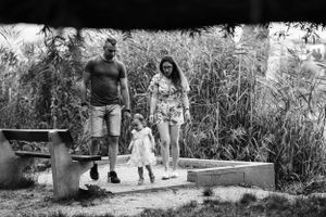 A black and white photo of a family walking down concrete steps in a natural setting.