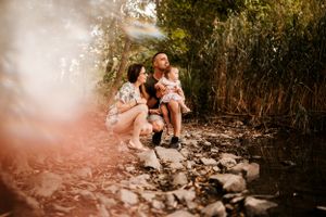 A loving family enjoying a warm summer evening together on a forest trail.