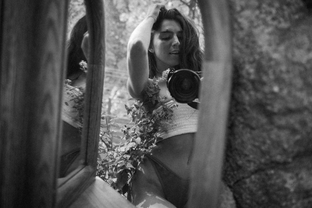 Artistic black and white mirror reflection showing someone in a bridal gown.