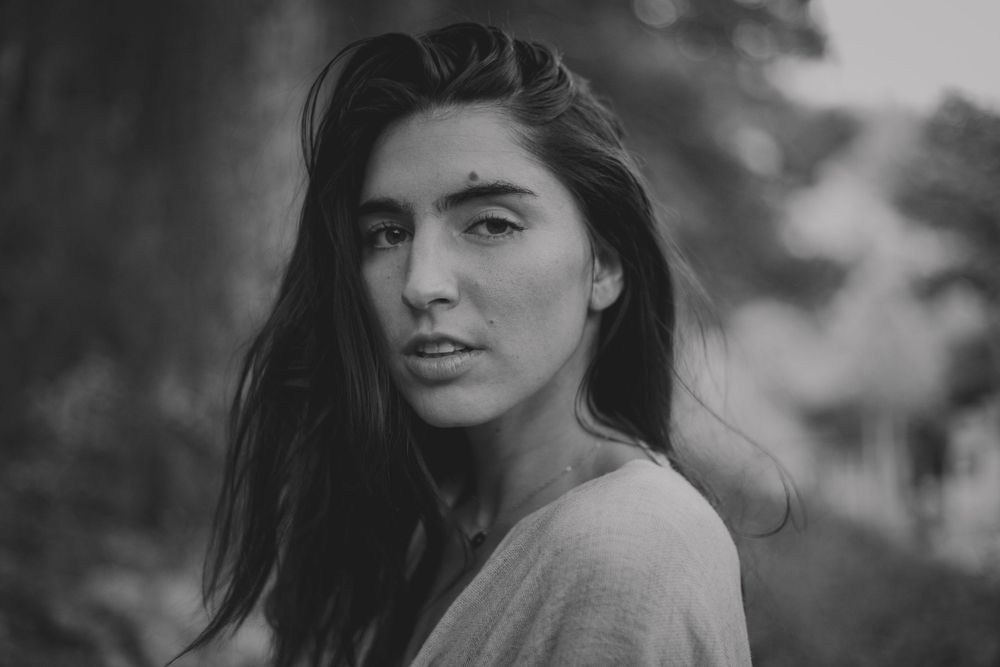 Black and white portrait with soft natural lighting against a dark background.