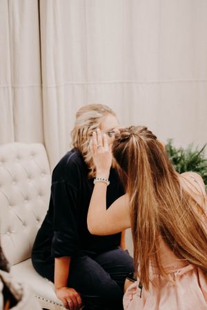 Two people embracing and laughing while sitting on a tufted cream couch.