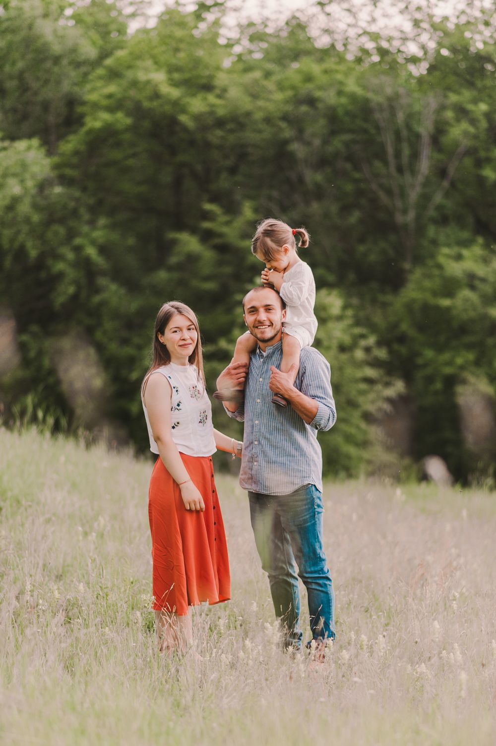 Family walking and playing together through a wildflower meadow at sunset.