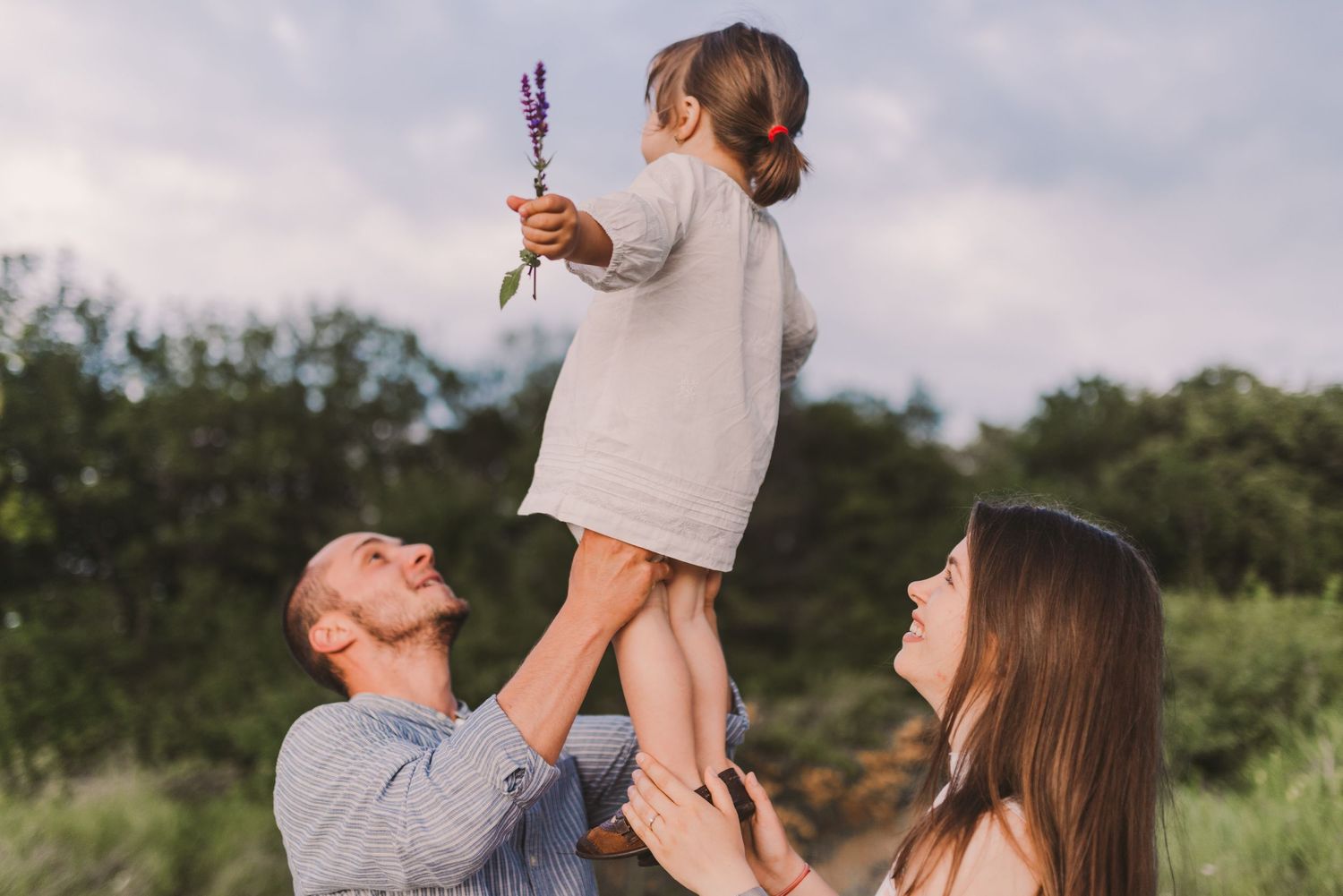 Candid moments of joy and laughter captured during an outdoor family photoshoot.