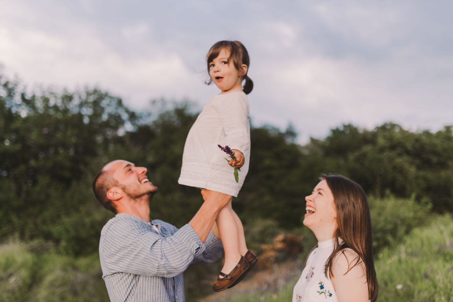 Playful family interactions captured during a golden hour photoshoot in nature.