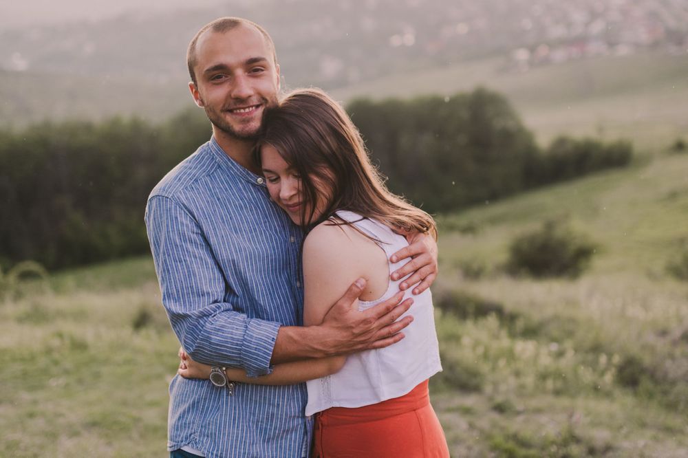 Sweet embraces shared between loved ones in an outdoor setting with natural lighting.