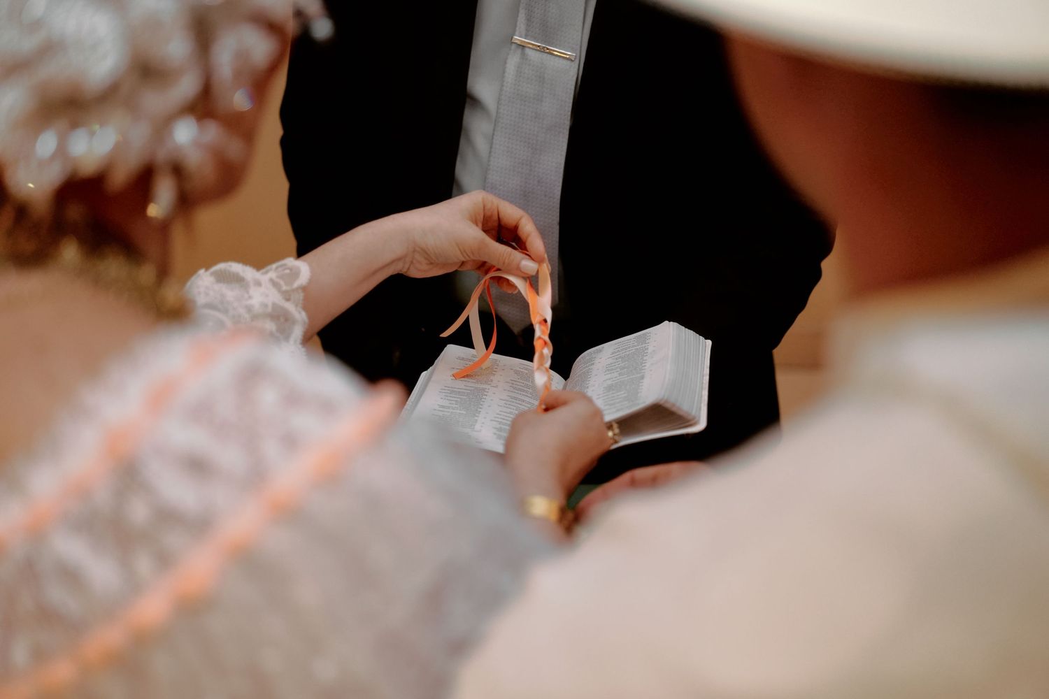 Close-up shot of hands exchanging rings during traditional wedding ceremony.