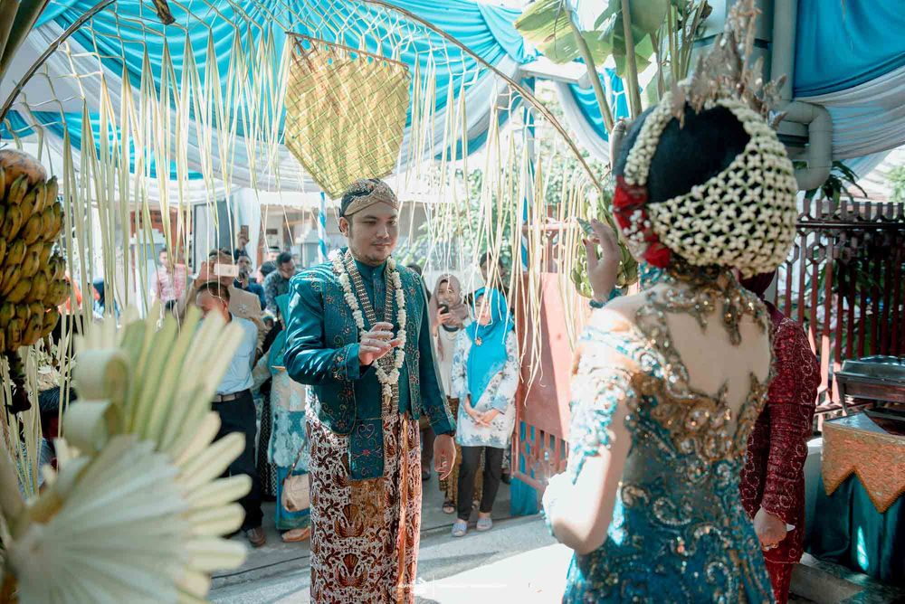Traditional Indonesian wedding ceremony with cultural attire and decorative elements.