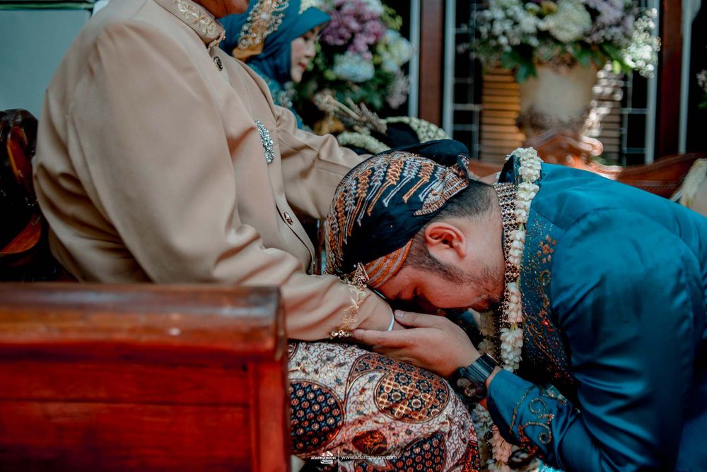 Traditional gesture of respect during Indonesian wedding ceremony.