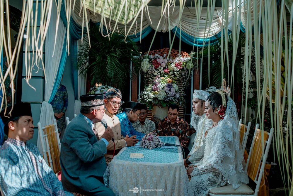 Wedding ceremony under decorative hanging strings and turquoise drapery.