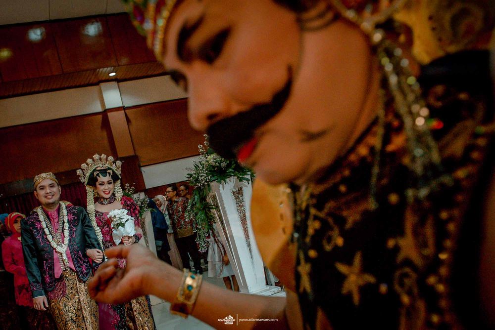 Wedding ceremony participants in traditional Indonesian formal dress during celebration.