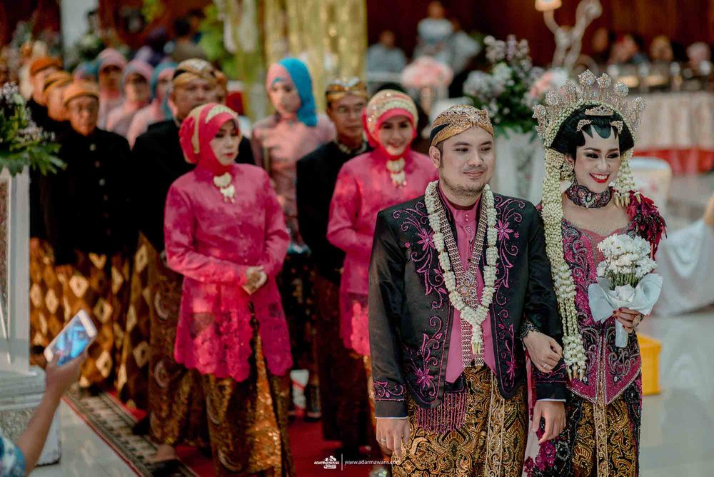 Wedding party members wearing traditional Indonesian formal attire in bright colors.