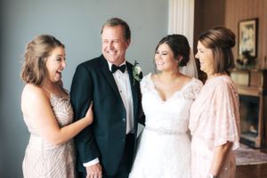 Joyful wedding party moment captured indoors with formal attire.
