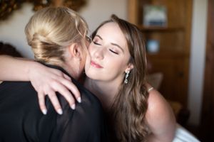 Tender emotional moment captured during wedding preparations.