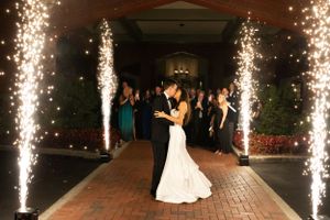 A couple shares their first dance surrounded by sparklers at an evening wedding celebration.