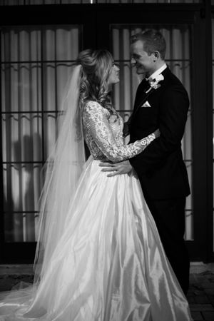 A black and white portrait of newlyweds in an intimate moment during their wedding ceremony.