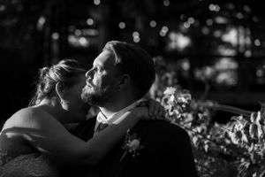 A romantic black and white portrait of a couple dancing outdoors.