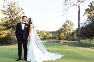 Romantic couple portrait on a sunny golf course with pine trees in the background.