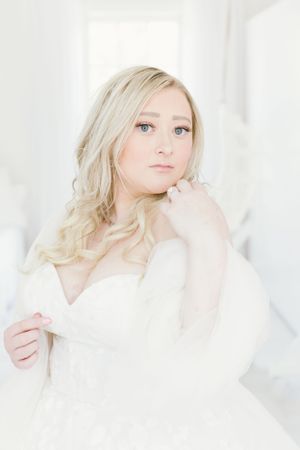 An ethereal bridal portrait with soft white tones and natural window light.