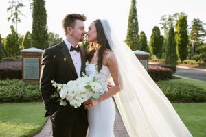 Intimate wedding portrait in a garden with white floral bouquet.