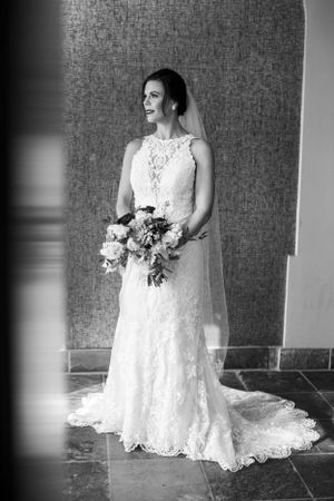 Elegant lace wedding gown with detailed train photographed in black and white.