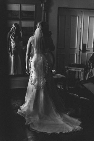 An elegant wedding dress with a long flowing train and veil captured in dramatic black and white.