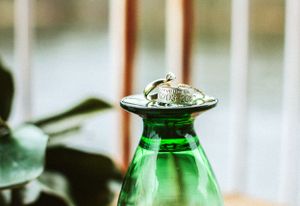 Wedding ring displayed on top of a green glass bottle.