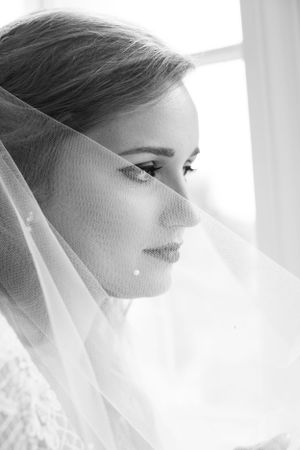 Ethereal bridal portrait with soft veil in natural window light.