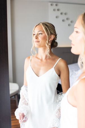 Getting ready scene with white silk robes and elegant updo hairstyles.