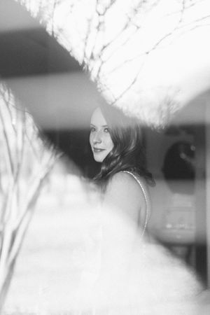 Artistic black and white portrait through textured glass creating ethereal effect.