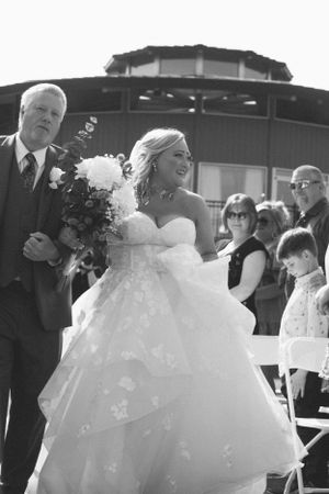 A black and white wedding photo capturing a joyful outdoor ceremony moment.