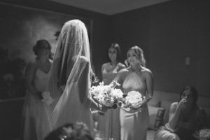 Black and white photo of a bridal party getting ready with white bouquets.