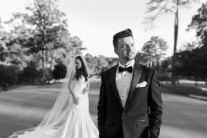 Black and white portrait on a golf course with elegant wedding attire.