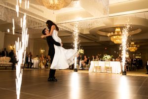 Dramatic first dance moment with sparklers illuminating a ballroom reception.