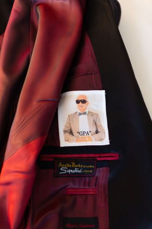 Custom suit jacket lining reveals personalized photo detail in burgundy and black tones.