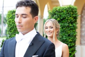 Elegant wedding couple sharing a private first look moment in formal attire.