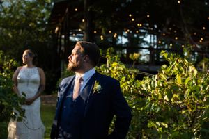 A wedding couple shares a candid moment in a garden setting during golden hour.