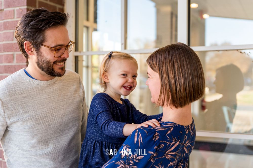 Family laughing together in historic Matthews, NC