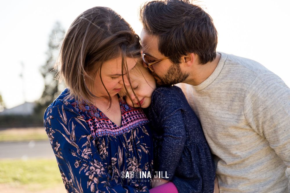 Family cuddling from the wind in Matthews, NC