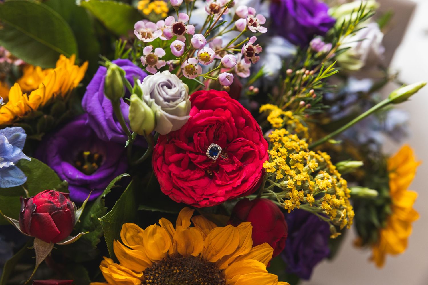 Engagement ring amongst the brides bright and colourful bouquet of flowers.