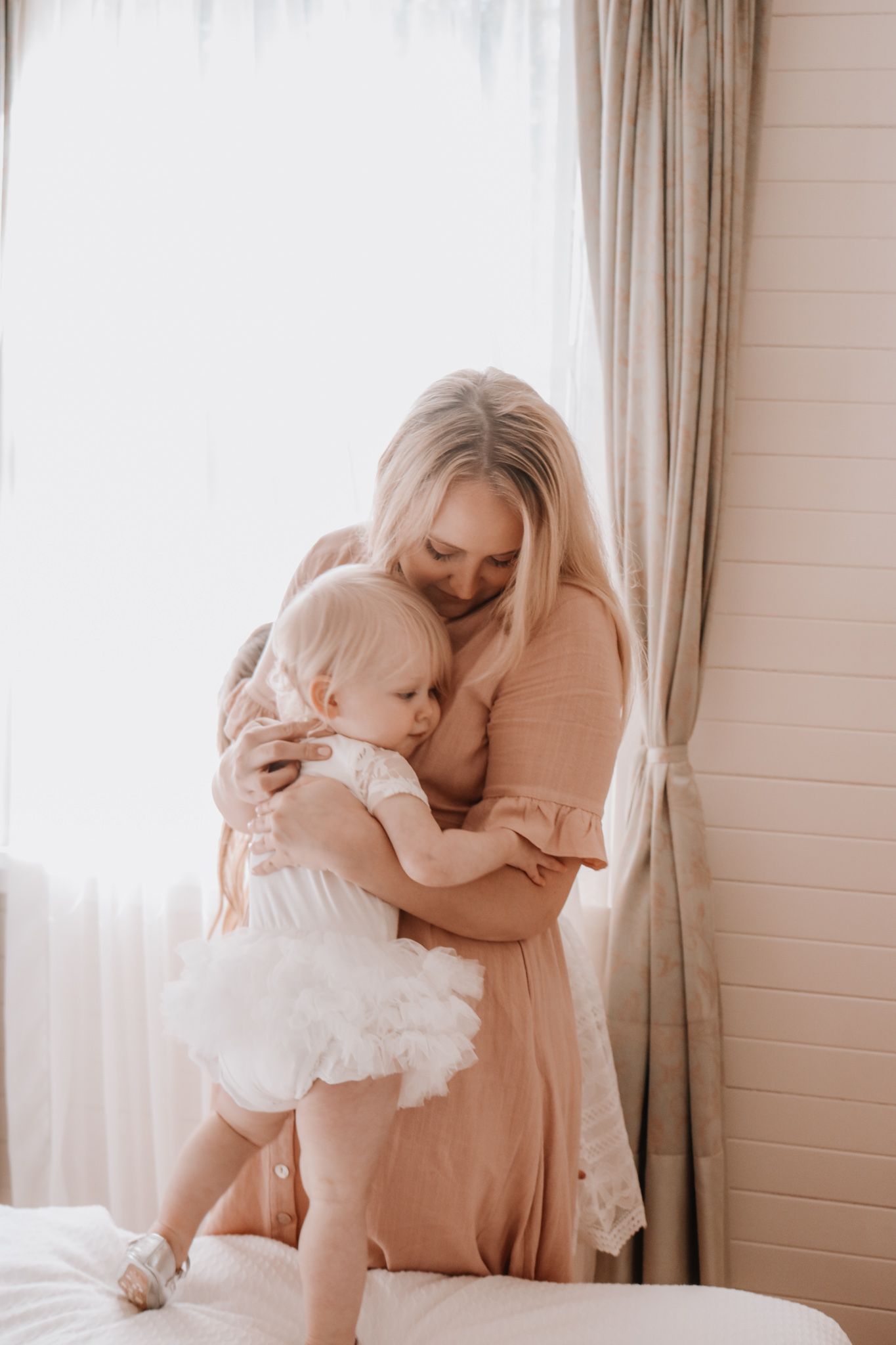 Tender moments between parent and child in soft natural window light.