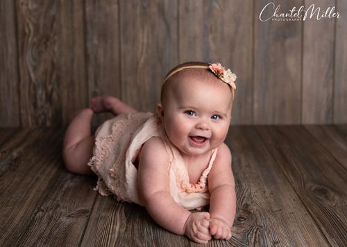 Baby girl smiling laying on tummy