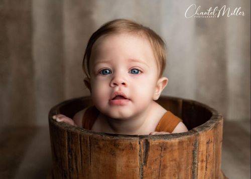 baby peeking out of bucket