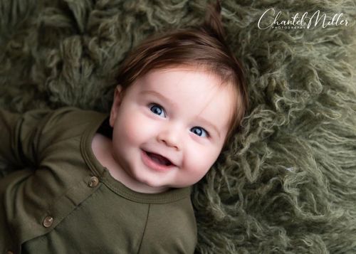 baby boy smiling laying on his back
