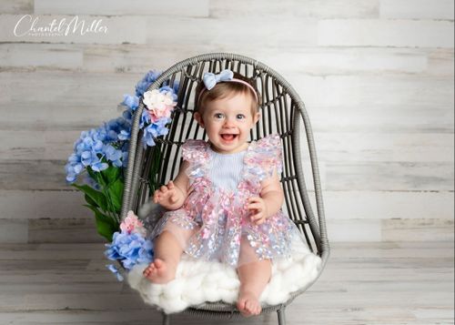 baby girl in chair smiling