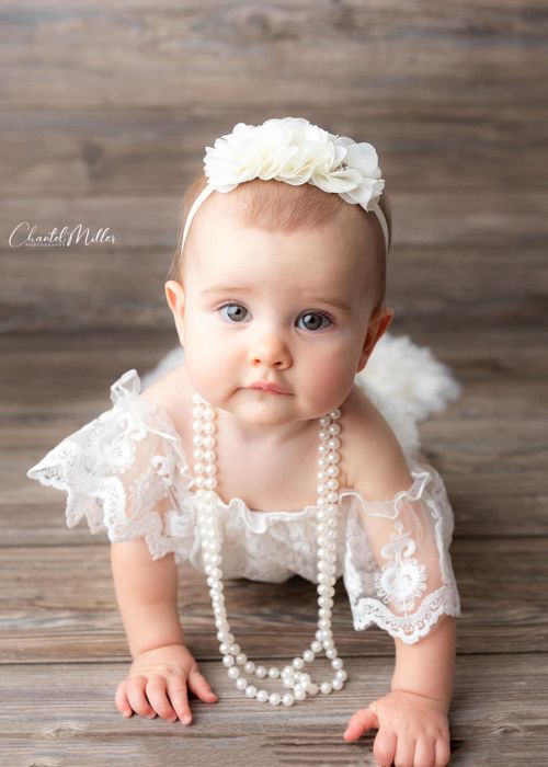 Baby girl in lace outfit crawling