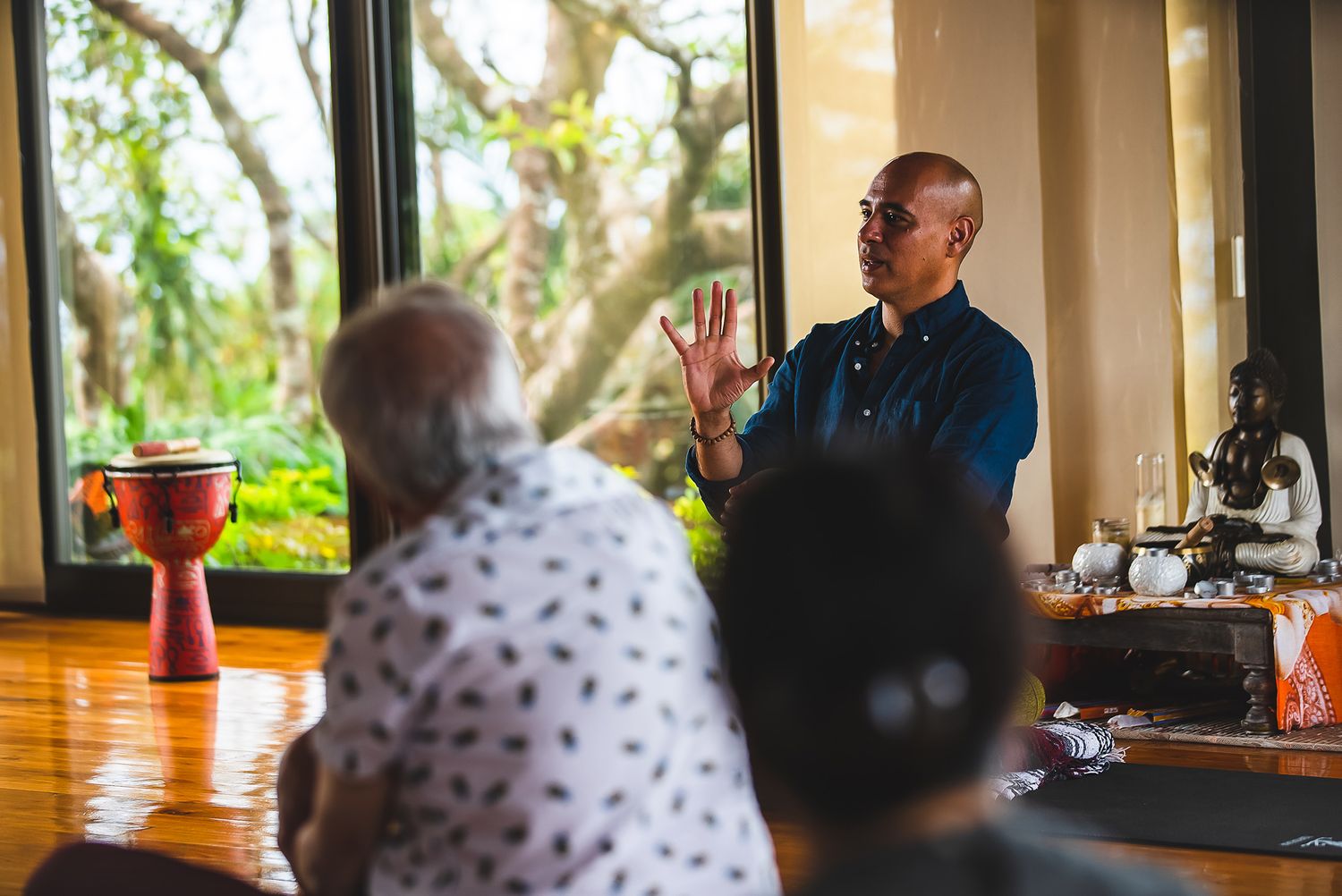 Wellness session participants engage in discussion at a bright windowed retreat space.